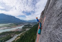 Hombre escalando en roca de montaña - foto de stock