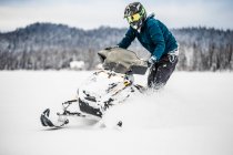 Homem em capacete snowmobiling na colômbia britânica — Fotografia de Stock