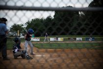 Visão traseira ampla de um adolescente no taco durante o jogo de beisebol — Fotografia de Stock
