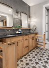 Badezimmer im Luxus-Eigenheim mit Waschtisch, Spiegel, Waschbecken und Fliesenboden — Stockfoto