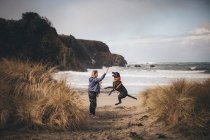 Mujer con un bebé está de pie en la playa californiana - foto de stock