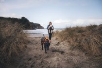 Une femme avec un bébé se tient sur la plage californienne — Photo de stock