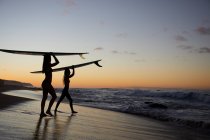Girls paddling out for Sunset Surf on the North Shore in Hawaii — Stock Photo