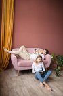 Young couple in love sitting on sofa and reading book — Stock Photo