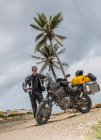 Чоловік, що стоїть поруч зі своїм пригодницьким мотоциклом після довгої подорожі, Колумбія. — стокове фото