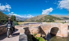 Moto dirigindo sobre uma ponte do Rio Urubamba, Peru — Fotografia de Stock