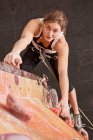 Young woman practising at indoor climbing wall in the UK — Stock Photo