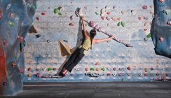 Mature woman practising at indoor climbing wall in the UK — Stock Photo