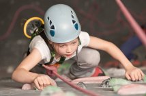 Giovane ragazza che si arrampica sulla parete di arrampicata al coperto in Inghilterra / Regno Unito — Foto stock