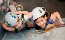 Two young girls climbing at indoor climbing wall in England / UK — Stock Photo