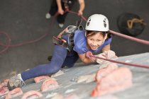 Jeune fille escalade au mur d'escalade intérieur en Angleterre / Royaume-Uni — Photo de stock