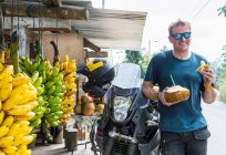 Мотоциклист наслаждается местными фруктами, Макала, Эль-Оро, Эквадор — стоковое фото