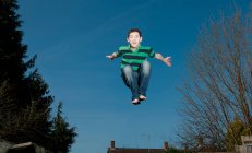 Menino pulando no trampolim em Woking - Inglaterra — Fotografia de Stock