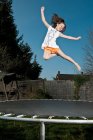 Jeune fille sautant sur trampoline à Woking - Angleterre — Photo de stock