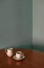 Kaffeetasse und Teekanne auf einem Ecktisch. Konzeptionelles Image — Stockfoto