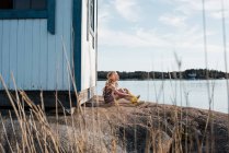 Retrato de adorable adolescente chica cerca de vieja choza de madera en la orilla del lago - foto de stock