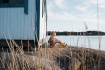 Portrait of adorable teen girl near old wooden shack on lake shore — Stock Photo