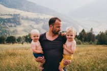Счастливый молодой отец с сыновьями в горах — стоковое фото