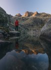 Un joven está parado sobre una roca durante el amanecer en Sierra de Gredos, Ávila, España, - foto de stock
