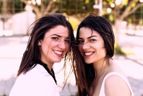 Portrait of two smiling friends posing together facing the camer — Stock Photo