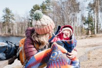 Mamma coccola sua figlia che ride mentre fa un picnic in famiglia — Foto stock