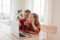 Kids showing chocolate to family on a video call during isolation — Stock Photo