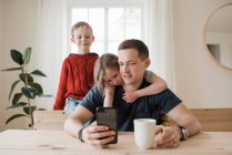 Padre e i suoi figli che ricevono una videochiamata da casa in isolamento — Foto stock