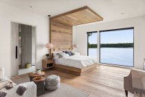 Спальня в новому розкішному будинку з дерев'яними підлогами і чудовим видом — стокове фото