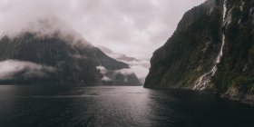 Blick auf Wasserfälle und Berge am Milford Sound bei nebligem Wetter, Neuseeland — Stockfoto