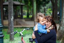 Mother and little boy cuddling in the park — Stock Photo