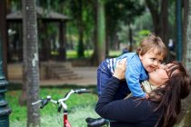Мать и маленький мальчик обнимаются в парке — стоковое фото
