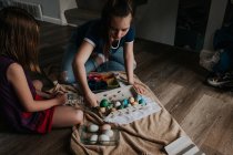 Sorelle sedute dentro morire uova di Pasqua insieme — Foto stock