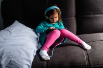 Junges Mädchen spielt iPad-Spiel auf der Couch — Stockfoto