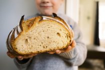 Гордый дошкольник хвастается своим домашним хлебом из теста. — стоковое фото