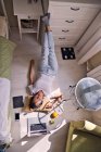 Молодая женщина лежит на полу дома с ноутбуком — стоковое фото