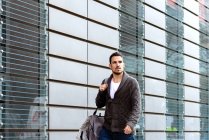 Young bearded man walking on the street next to office building — Stock Photo