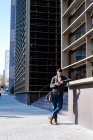 Man using smartphone outdoors, standing next to office building — Stock Photo