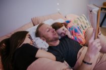 Primer plano retrato de padre leyendo a sus hijas - foto de stock