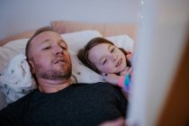 Primer plano de padre leyendo a la joven hija feliz - foto de stock