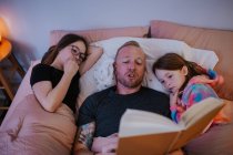 Overhead of dad reading to children — Stock Photo