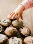 Child hand touching homemade cupcakes — Stock Photo