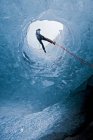 Man rappelling into glacier cave on Slheimajkull glacier in Iceland — Stock Photo