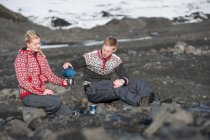 Молодая пара устраивает пикник в бесплодной местности Исландии — стоковое фото