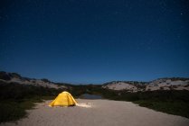 Шатер в горах в красивом ночном небе — стоковое фото