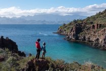 Una donna e suo figlio in piedi su una roccia in una spiaggia dell'isola Del Carmen — Foto stock
