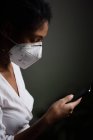 Woman with face mask using a smartphone — Stock Photo