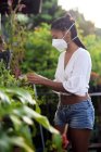 Young woman gardening in face mask — Stock Photo