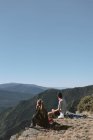 Chica y niño en las montañas observando el paisaje mientras descansan - foto de stock