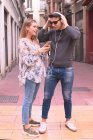 Attraktives junges Paar hört Musik mit Kopfhörern — Stockfoto
