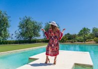 Ragazza bionda in posa in estate con un vestito a bordo piscina — Foto stock